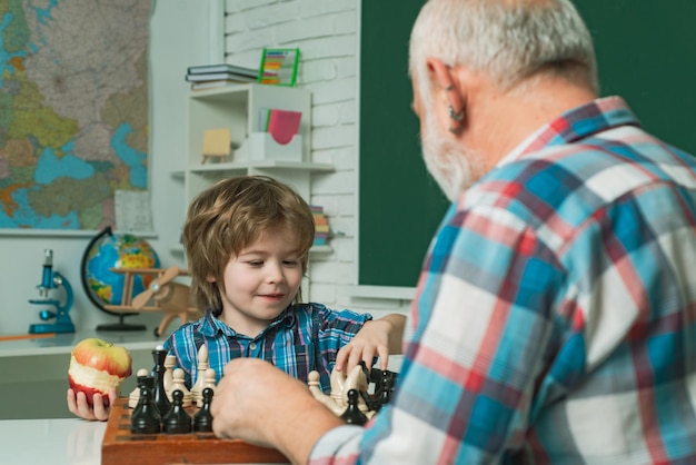 Фото Дедушка и внук играют в шахматы, дедушка учит дедушку в шахматной школе