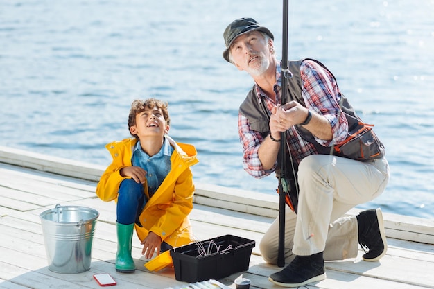 Grandfather and boy looking at fishing tackle