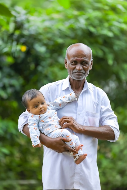 Grandfather carrying his granddaughter on his hand.