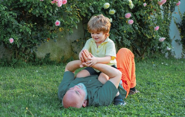 Grandfather carrying his grandson having fun in the park at the sunset time healthcare family lifest