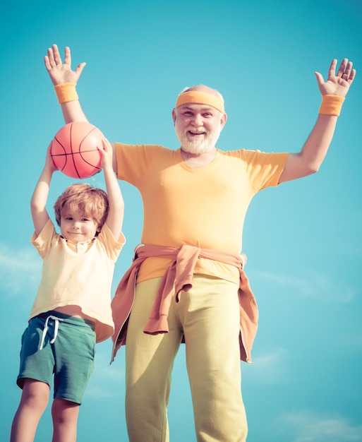 Grandfather and child training together Be in motion Senior man and child in family health club Senior man and child exercising on blue sky