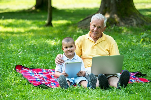 공원에서 태블릿 컴퓨터를 사용하는 할아버지와 아이