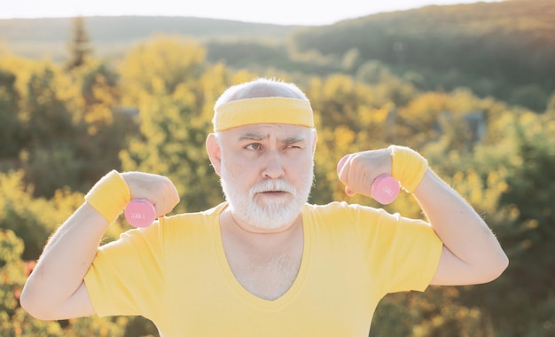 Grandfather exercising with dumbbell sport for senior man senior man in park working out with weights