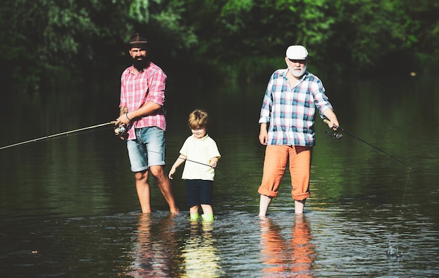 Дедушка, отец и внук, вместе рыбачащие вместе, ловят рыбу нахлыстом, отец учит своего сына