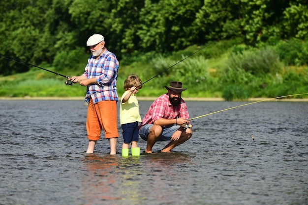 Grandfather father and grandson fishing together family fishermen fishing with spinning reel