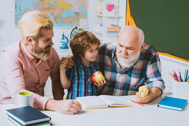 Grandfather father and son learning to write and read men generation three different generations age