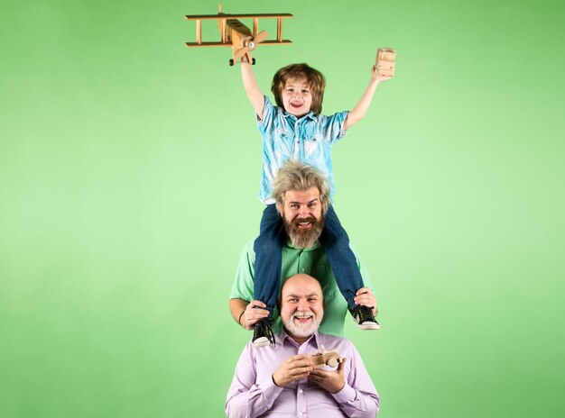 Grandfather father and son playing with toy plane happy man\
family men generation happy childhood