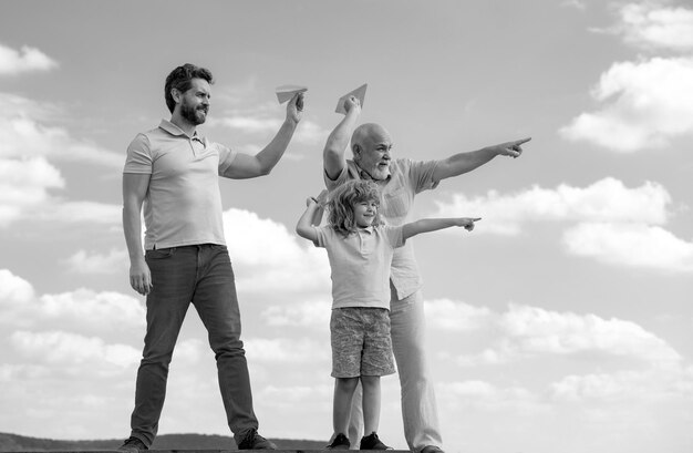 Foto nonno padre e figlio che giocano con un aereo giocattolo all'aperto sul cielo famiglia felice tre uomini generazione