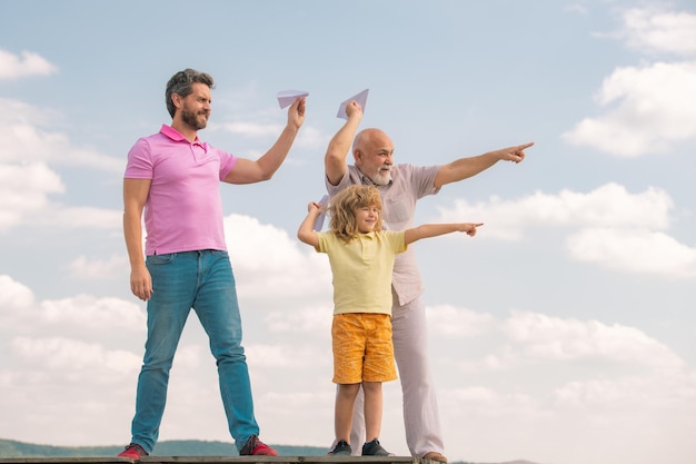 할아버지 아버지와 아들이 야외에서 장난감 비행기를 가지고 노는 하늘 행복한 가족 3세대