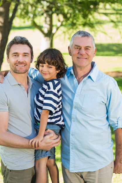 Grandfather father and son smiling at park