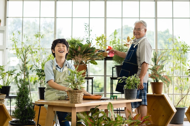 Дедушка садоводство и обучение внука уходу за растением в помещении