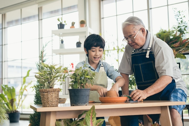 Grandfather gardening and teaching grandson take care  plant indoors