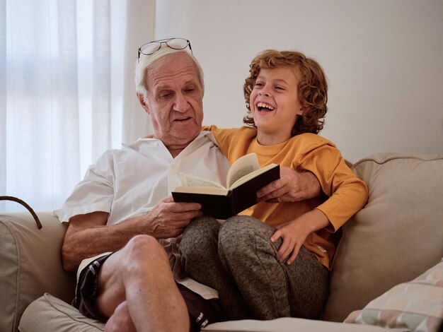 Grandfather and grandson bonding while reading together at\
home