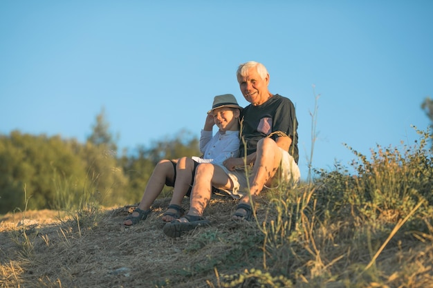 Nonno e nipote che si divertono all'aperto sorridendo e abbracciando concetto di famiglia amichevole