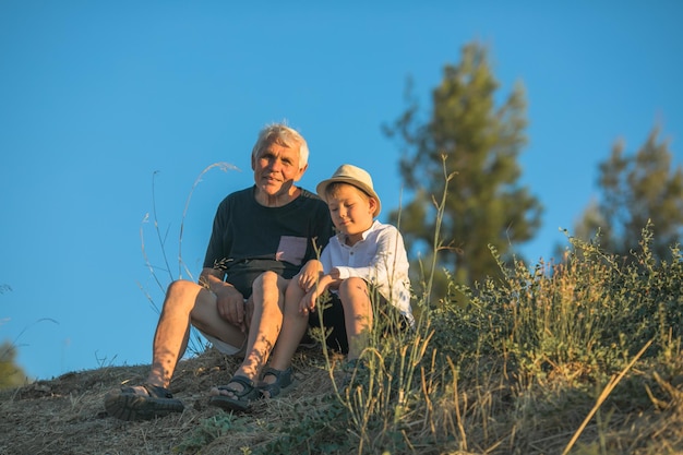 Nonno e nipote che si divertono all'aperto sorridendo e abbracciando concetto di famiglia amichevole