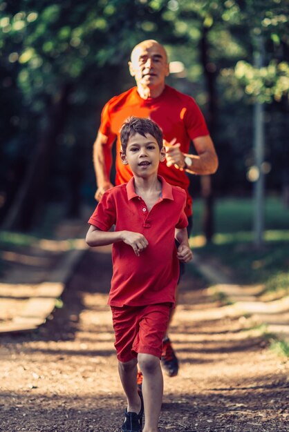 Grandfather and grandson jogging in park