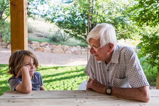 A grandfather and grandson sitting talking.