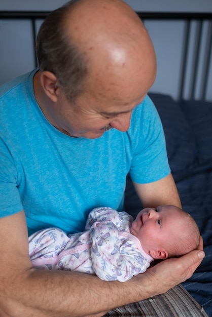Grandfather holding a beautiful newborn baby girl