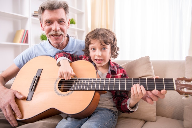 Il nonno suona la chitarra con suo nipote.