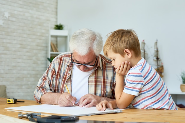 Grandfather and Little Boy Drawing Together