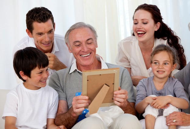 Дед смотрит на фотографию с семьей