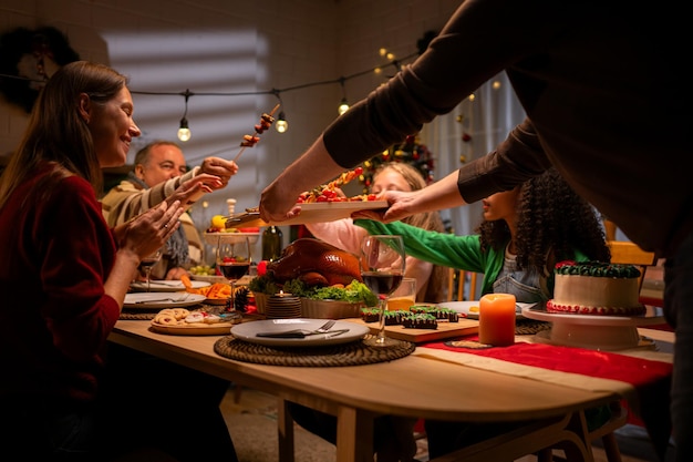 Grandfather parents and the teenage girls are all having dinner together at home on Christmas night