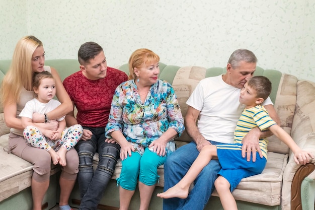 Grandfather plays with his grandson, telling him a secret, whispering in his ear