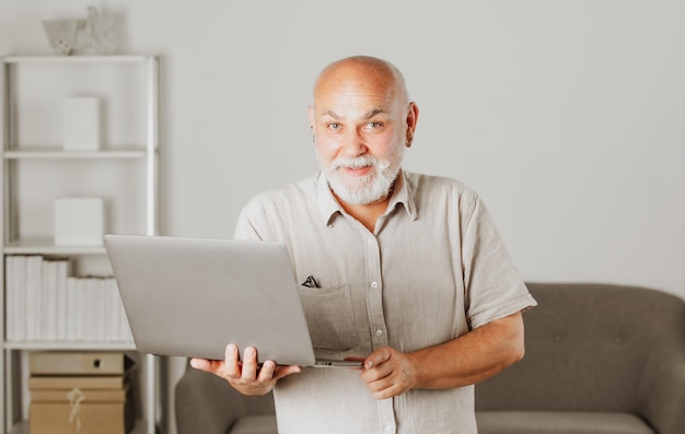 Дедушка портрет пожилого мужчины с ноутбуком старший мужчина с седой бородой дома зрелый мужчина за компьютером