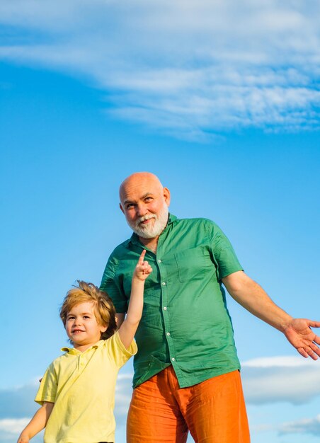 Grandfather and son cute child boy hugging his grandfather grandson embrace his grandfather senior m...