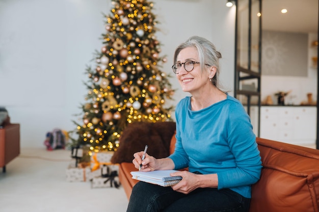 Grandma sits on the couch writing something in a note