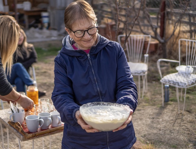 Grandma smiling showing a bowl with homemade cream