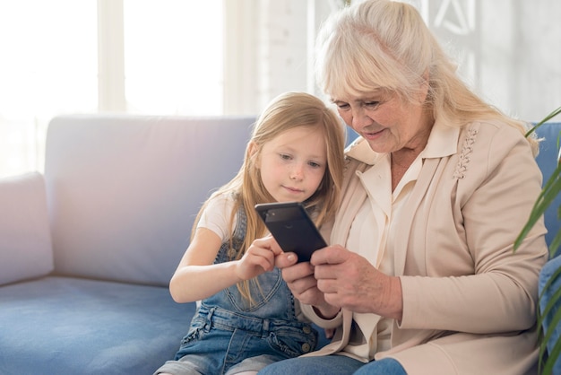 祖母と女の子の携帯電話を使用して