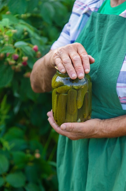 Grandmother canning cucumbers for the winter. Selective focus.