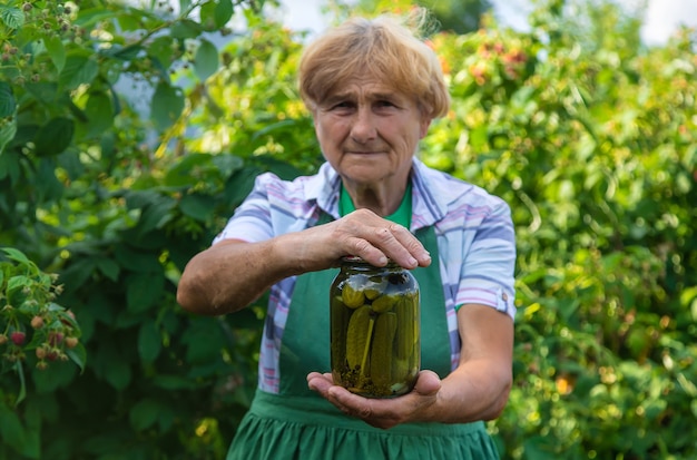 Бабушка консервирует огурцы на зиму. Выборочный фокус.