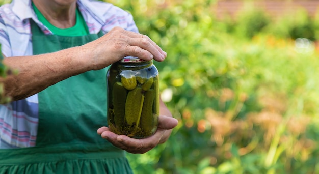 Grandmother canning cucumbers for the winter. Selective focus.