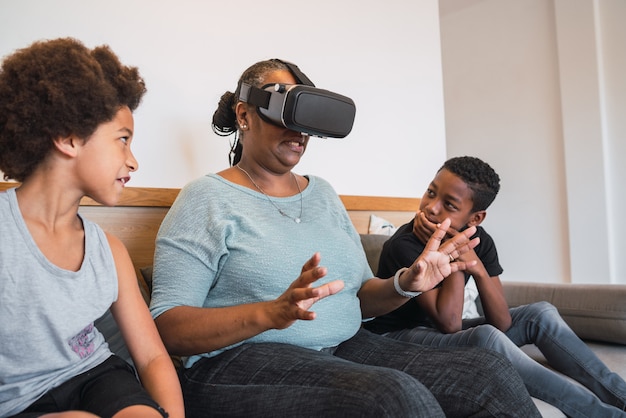 Grandmother and grandchildren playing together with VR glasses.