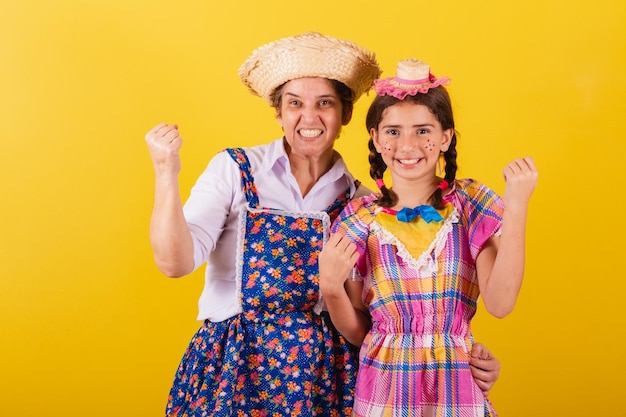 Grandmother and granddaughter dressed in typical Festa Junina clothes Celebrating victory partying