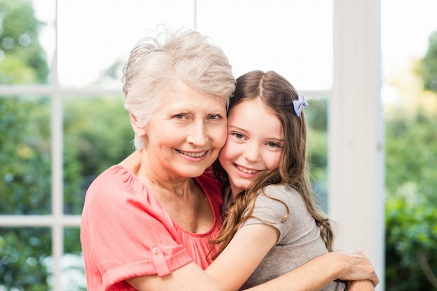 Grandmother and granddaughter embracing at home