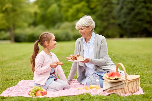 公園でピクニックをしている祖母と孫娘