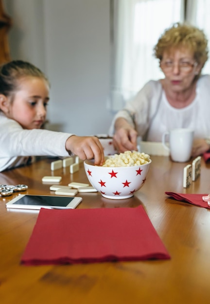 Grandmother and granddaughter playing domino in the living room