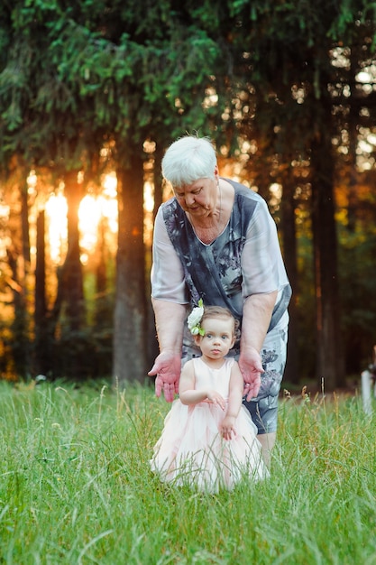 Grandmother and granddaughter walk in the park