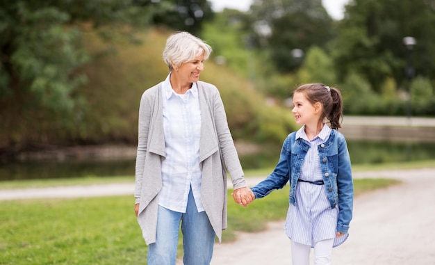 grandmother and granddaughter walking at park