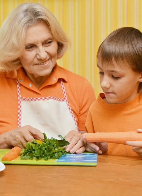 Grandmother and grandson cutting vegetables