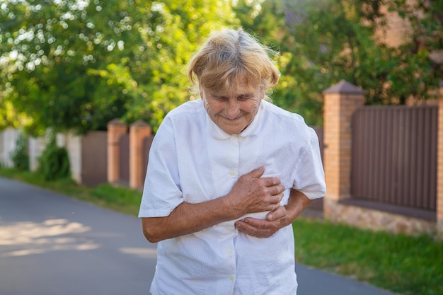 Grandmother has an old woman with a heart ache. Selective focus.