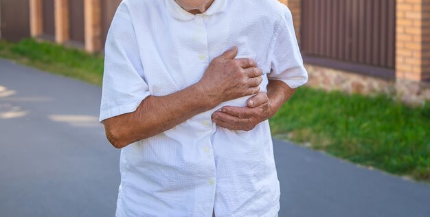 La nonna ha una donna anziana con un dolore al cuore. messa a fuoco selettiva.