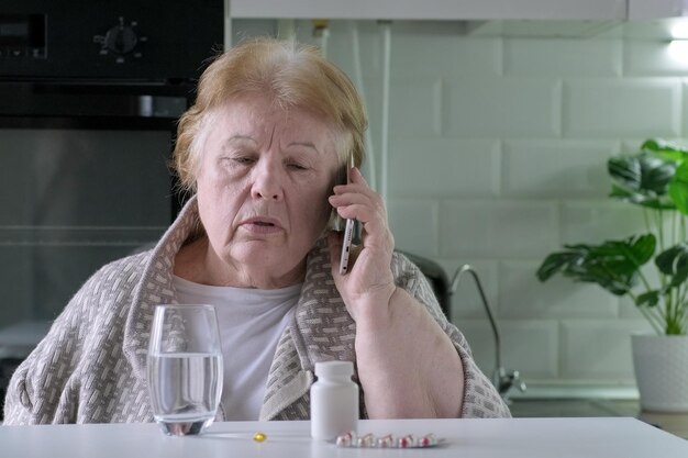 Photo grandmother holding cellphone having online distant communication about medicine