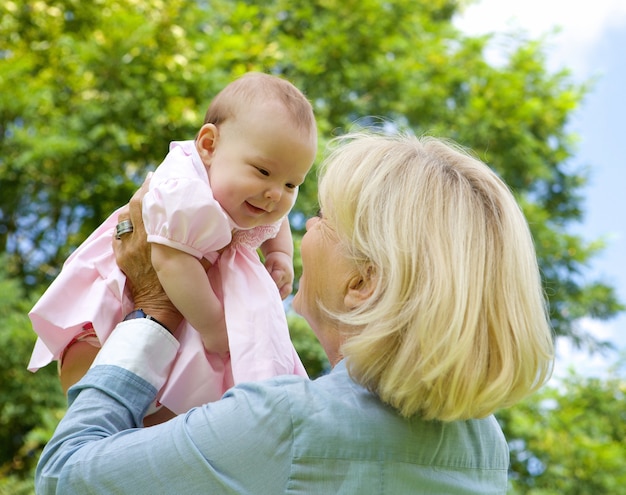 Grandmother lifting grandchild up and playing