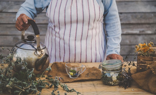 La nonna fa il tè con le erbe medicinali messa a fuoco selettiva