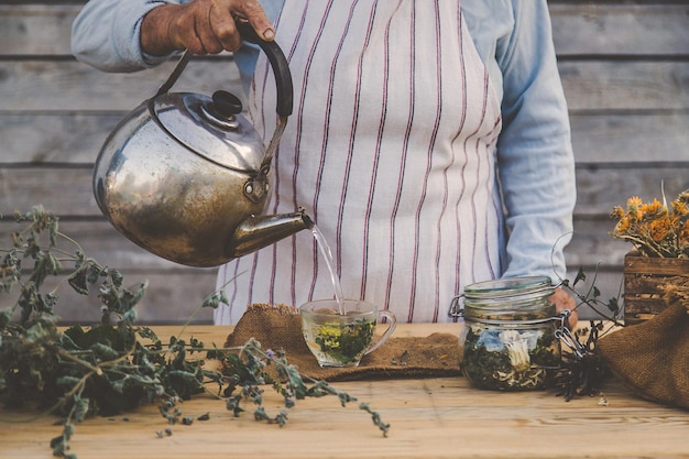 Grandmother makes tea with medicinal herbs selective focus