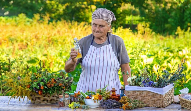 Foto la nonna fa tinture da erbe medicinali messa a fuoco selettiva